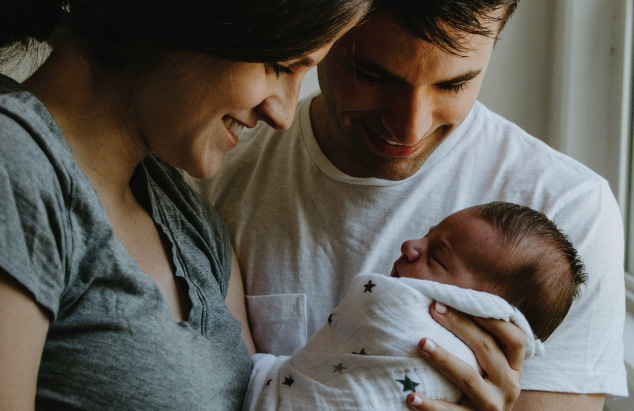 Couple smiling at their newborn child